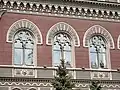 Second floor Gothic windows with elements of rose windows.