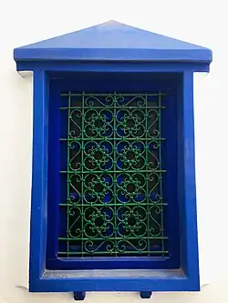 Image 48A window displaying a wrought iron window grill in Asila. The knots are tied with bent metal in the traditional way, rather than soldered. (from Culture of Morocco)