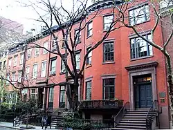 Photo of a 3-story red brick building, taken from street outside