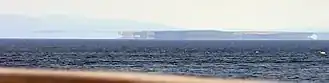 Distant shadowy appearances of land, seen across a wide expanse of sea