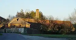 The buildings and chimney of the Mélecey saltworks.