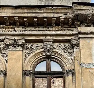 Pair of foliate heads flanking a corbel above a window of Strada Justiției no. 46, Bucharest, Romania, unknown architect, c.1900