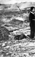 A charred body and a woman stunned with shock