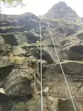 A climber starts to rappel down Rooster Rock