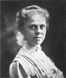 B&W portrait photo of a middle-aged woman wearing a pale dress, with her hair in an up-do