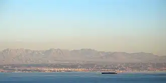 Haql seen from the sea, with the Midian Mountains in the background