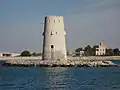 Al-Maqta' Tower (Arabic: بُرْج ٱلْمَقْطَع, romanized: Burj Al-Maqṭaʿ; front) and Al-Maqta' Fort (Arabic: حُصْن ٱلْمَقْطَع, romanized: Ḥuṣn Al-Maqṭaʿ; back), just outside the island of Abu Dhabi