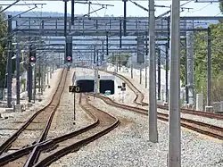 A tunnel between two mainline tracks, with two tracks spurring off to enter the tunnel