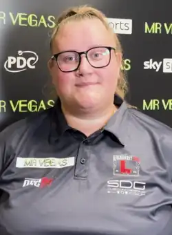 Beau Greaves, facing straight forward in front of a panel with sponsors' logos at a press conference.