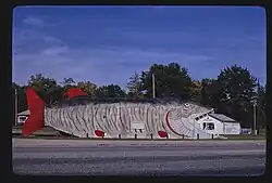 large building-sized wooden structure shaped like a striped fish
