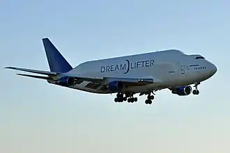 Side quarter view of four-engine jet climbing in the sky.
