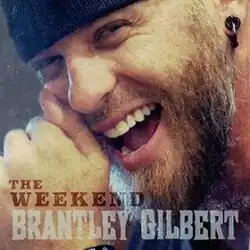 An image of a smiling bearded man, sporting a black toque and earring.