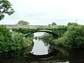 a stone bridge, viewed from the river below