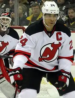 A defenseman in front of a goaltender during a game of ice hockey.