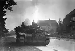 A large mechanised vehicle drives down a suburban road