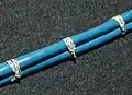 Spot ties formed with a clove hitch topped by a reef knot made in modern Nomex lacing tape. A surgeon's knot is an acceptable substitute for the reef knot.[10]