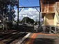 Partial view of station signal box and traffic stopped at the Station Street level crossing, August 2019