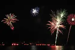 Fireworks during the Ring of Fire; the red lights at the bottom are flares