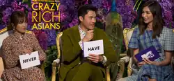Constance Wu, Henry Golding, and Gemma Chan hold white cards with "never" and "have" on them