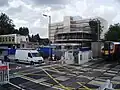 British Rail Class 450 approaching Cosham railway station while motorists and pedestrians wait