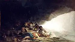 A group of women and a man lying inside a cave and a small group of donkeys.