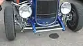 Deuce coupe featuring '32 grille shell, original headlights, chrome dropped I-beam axle and tube shocks. Note stock frame rails, disc brakes, Lakester pipes[32]