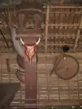 A column with images of rhino horns, a hag head, and a ding nam.
