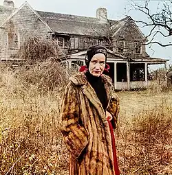 Beale standing in front of a house