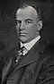 Black and white photograph of Ernest Martin Hopkins with short hair, wearing a suit, tie, and collared shirt.
