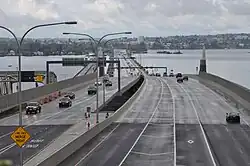 A long floating bridge crossing a lake in a suburban area