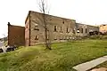 North side of buildings, with Stable/Maintenance Building in foreground and Engine House behind. View to southwest.