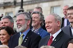 Photograph of two smiling men in crowd