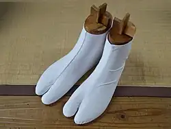 A pair of white tabi. Tabi are traditional Japanese socks with split-toe construction.