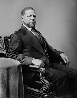 Black-and-white portrait of Revels sitting and facing right