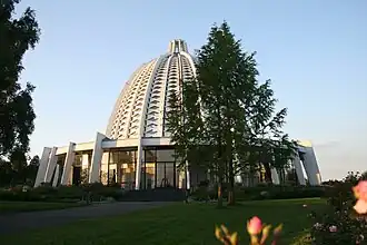 A white domed building with palm trees in front of it