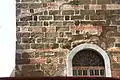 Wall composed of stone and bricks in alternating layers