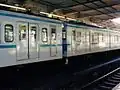 A JR East 301 series (left) and 103–1200 series (right) EMU formation at Funabashi Station, August 2002