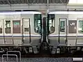A 223–5000 series (right) coupled with a JR Shikoku 5000 series (left)