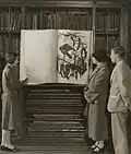 Two women exhibiting a large folio with a drawing of birds by John James Audubon