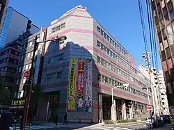 Modern multi-story office building with glass facade in urban Tokyo setting