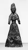 Baltimore stone figure, probably a fake, pre-1929. A snake winds round the headdress and the hands are pierced as if to hold snakes.