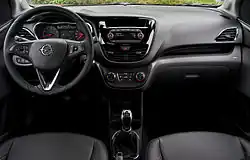 Dashboard of left-hand-drive car with rotary climate controls, a manual gearbox, and a handbrake