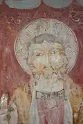 Allegory of the Holy Trinity, painted as three faces fused in one, medieval fresco in Perugia