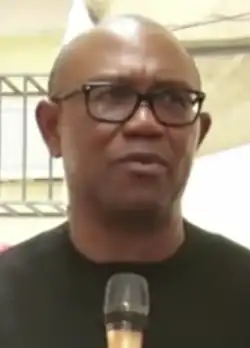 Obi, with a microphone addressing a crowd