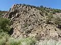 Piedra Lumbre Formation, upper left, in contact with thinner beds of Pilar Formation, lower right