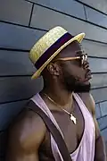 American man wearing a vintage style boater hat in 2017, showing the longevity of hipster style across the decade.