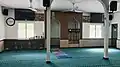 The mihrab and minbar of the mosque, along with a cabinet full of mushaf (copies of the Qur'an).