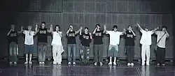 The members of Seventeen holding hands to bow at the end of a concert