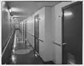 A passenger hallway whose lack of decoration was described as having decor compared to that of a warship.