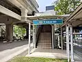An entrance to the station along the road. A flight of stairs leads to the concourse level